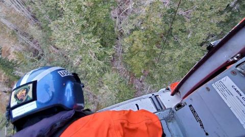 A US Coast Guard helicopter hovers as it lowers a rescue basket to hoist the runner out of the park.