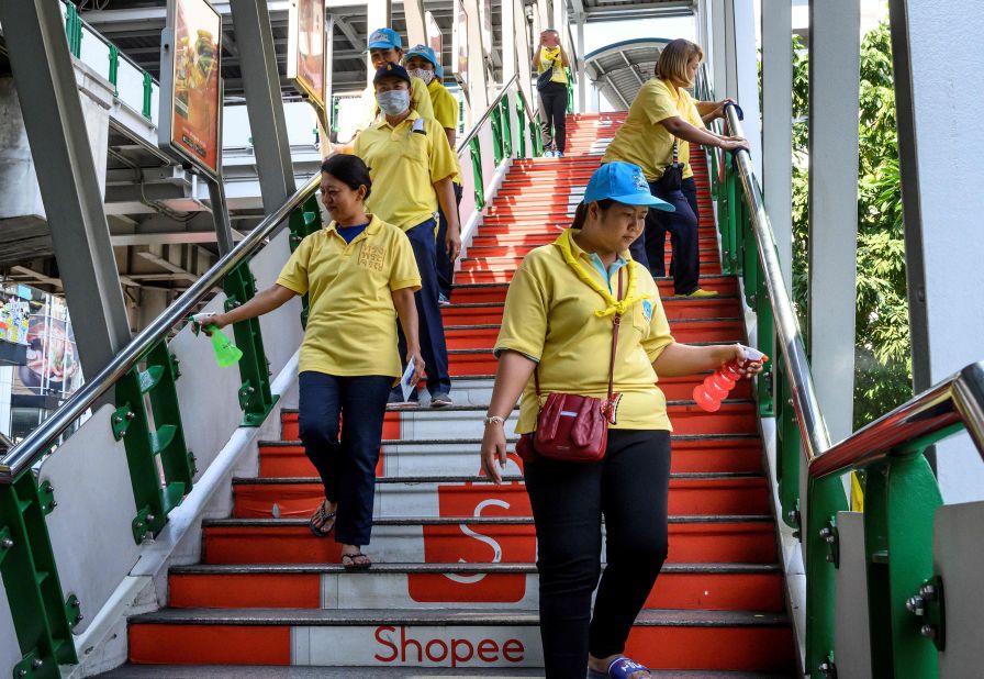 A team of volunteers disinfects a pedestrian bridge in Bangkok, Thailand.