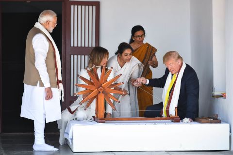 Trump holds a string while viewing a charkha, or spinning wheel, during a visit to the Gandhi Ashram in Ahmedabad.