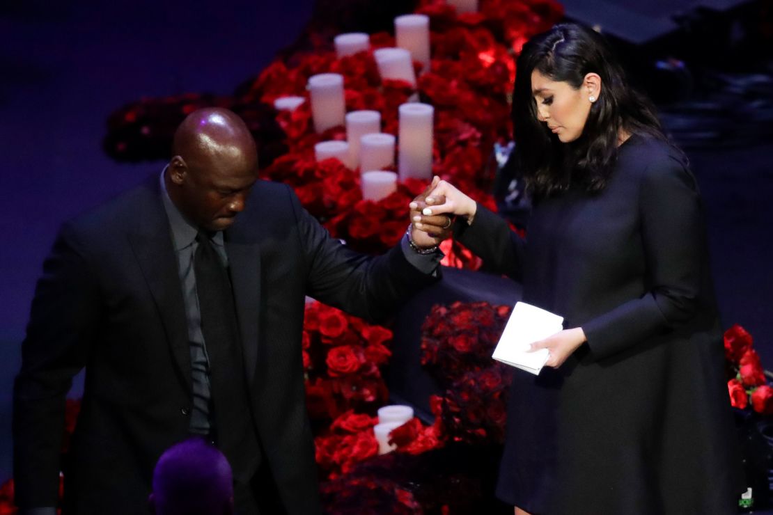 Vanessa Bryant is helped off the stage by former NBA player Michael Jordan.