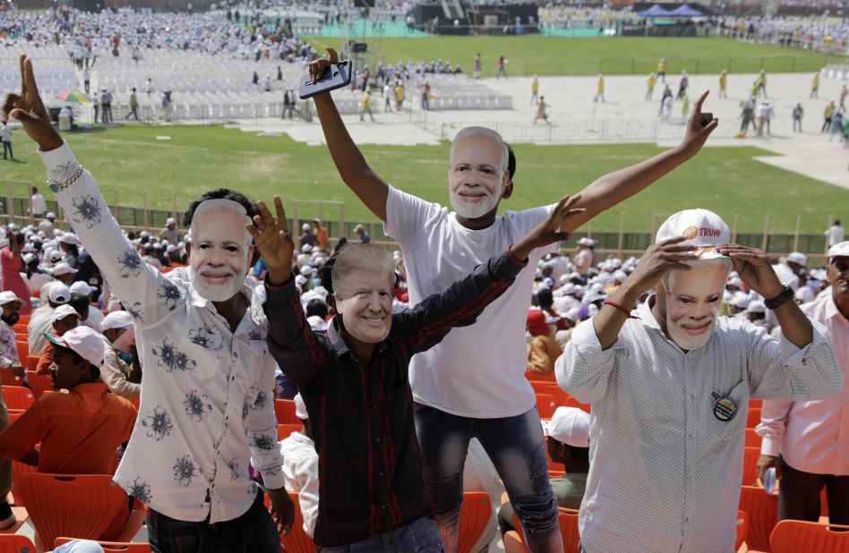 Members of the crowd don Modi and Trump masks.