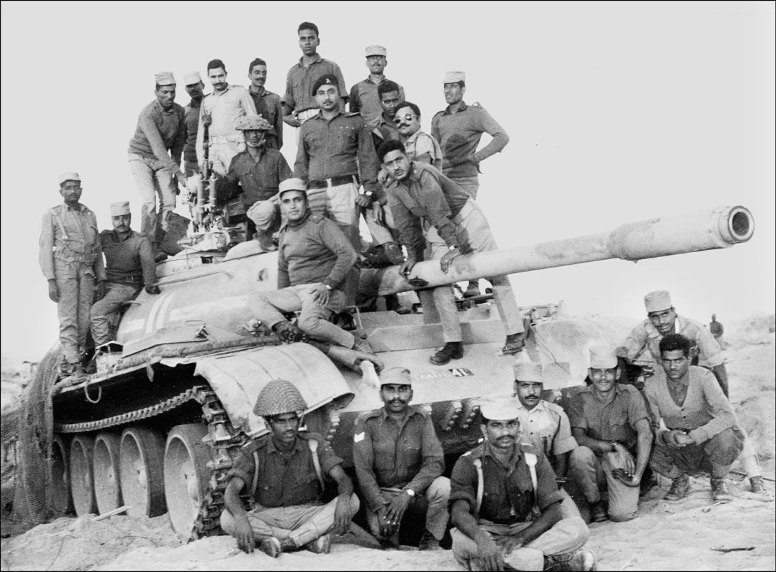 Indian army officers and soldiers on December 11, 1971, stand on a captured Pakistani tank in the desert of the state of Rajasthan during the India-Pakistan border conflict. 