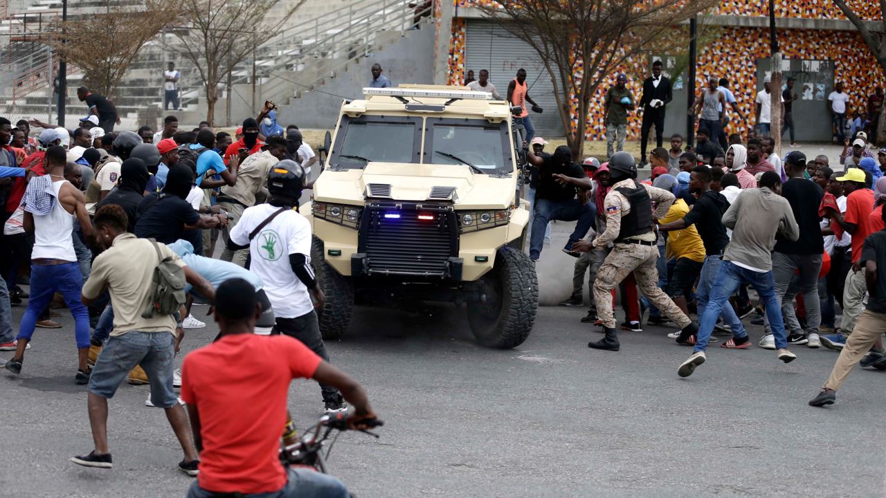 Armed off-duty police officers commandeer an armored vehicle during a protest over police pay and working conditions, in Port-au-Prince, Haiti, Sunday, Feb. 23, 2020.