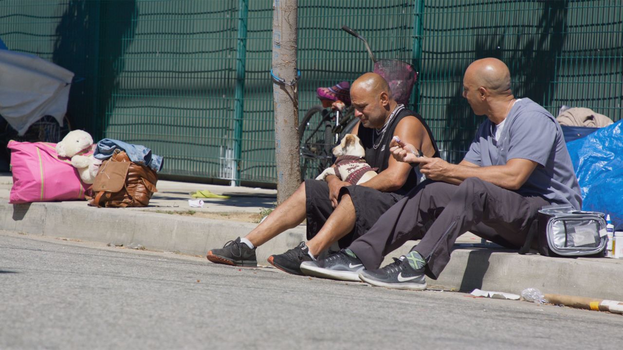 A homeless man named Mike crying while Stewart treats his dog, Goldie.