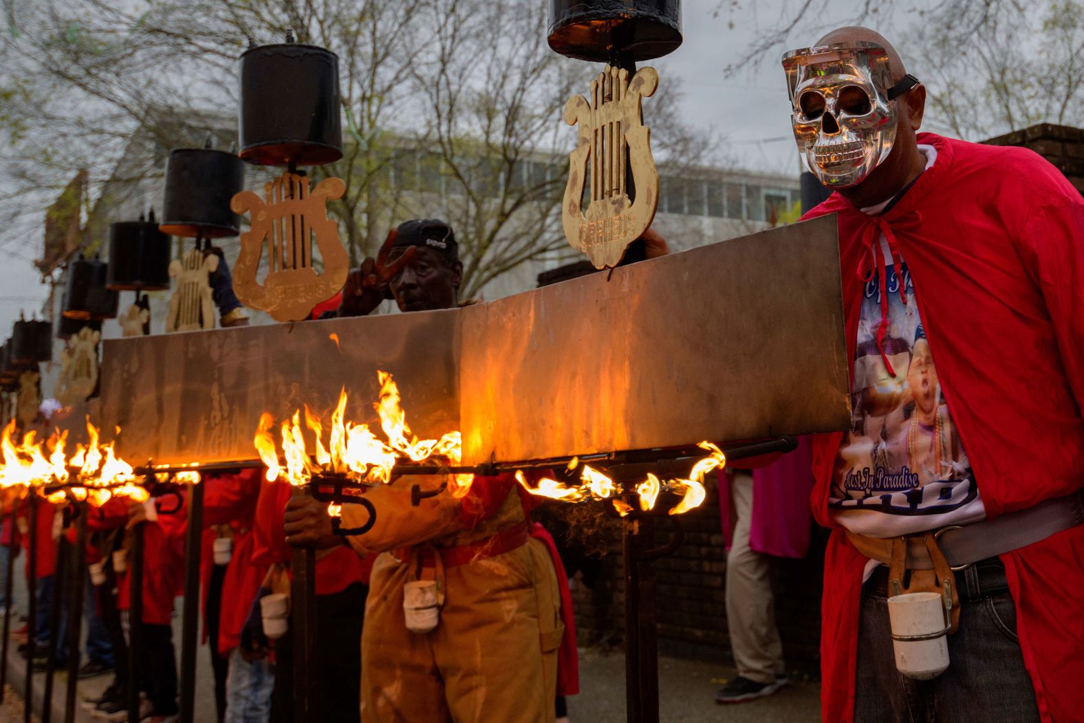 Flambeaux, a group that recreates how parades were lit up with torches before electricity, walks in front of the Krewe of Orpheus float.