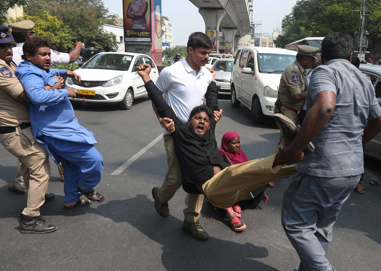 Police officers in Hyderabad, India, detain people who were protesting Trump on Tuesday.