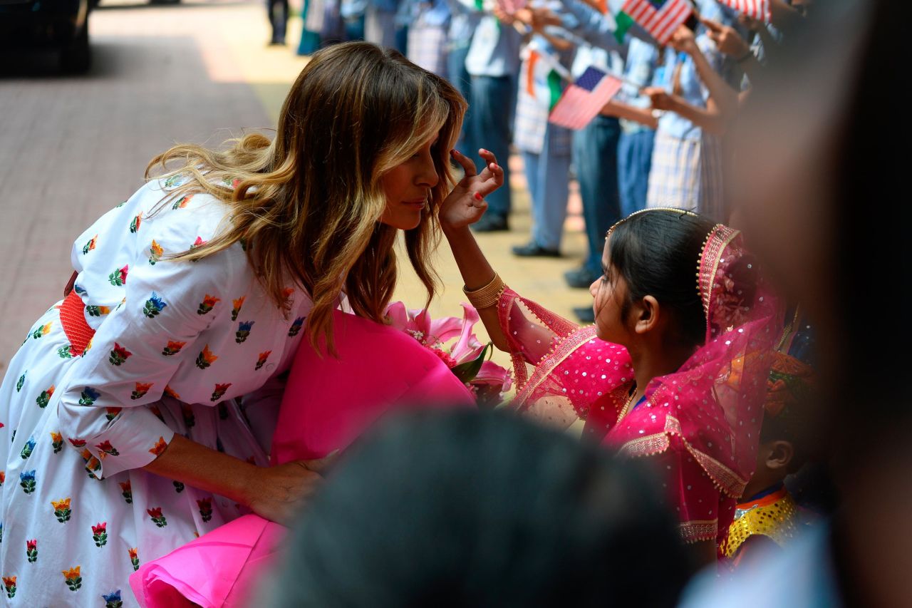 A student applies vermilion powder on the first lady's forehead as she visits a secondary school in New Delhi on Tuesday.
