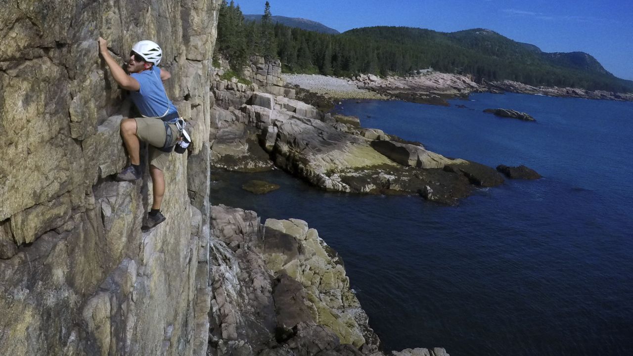 <strong>Acadia National Park:</strong> Mountain guide Mark Warner climbs Wonder Wall, a rock climbing route at Otter Cliffs. The Maine park attracted 3.4 million visits last year. 