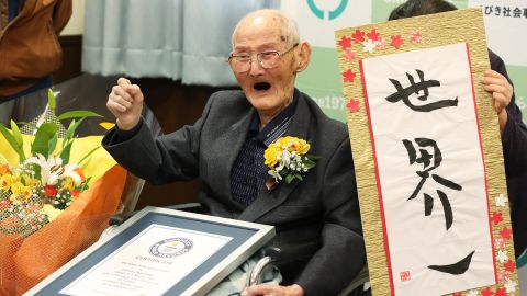 112-year-old Japanese man Chitetsu Watanabe poses next to calligraphy reading in Japanese 'World Number One' after he was awarded as the world's oldest living male in Joetsu, Niigata prefecture on February 12.