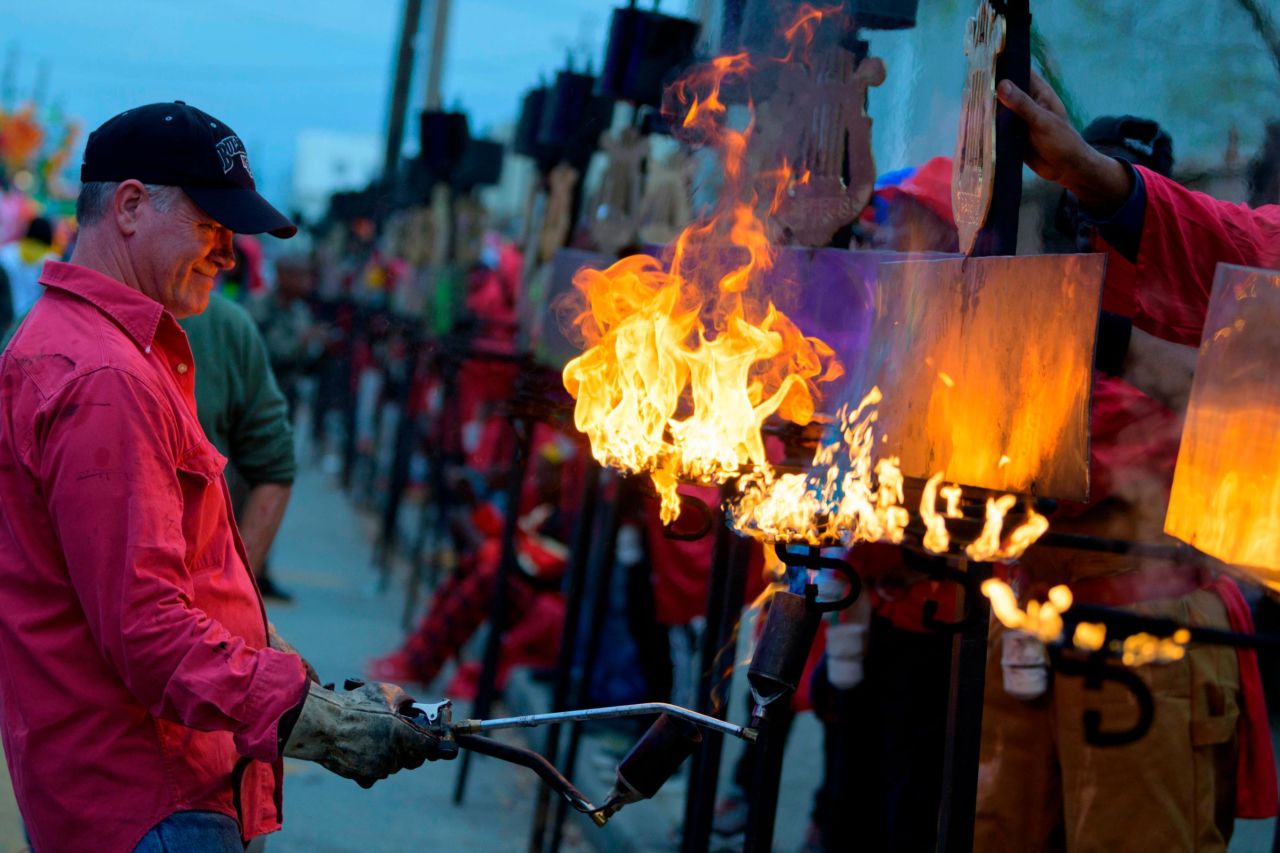 Flambeaux are lit before the start of the Krewe of Orpheus along the Uptown parade route on Monday.