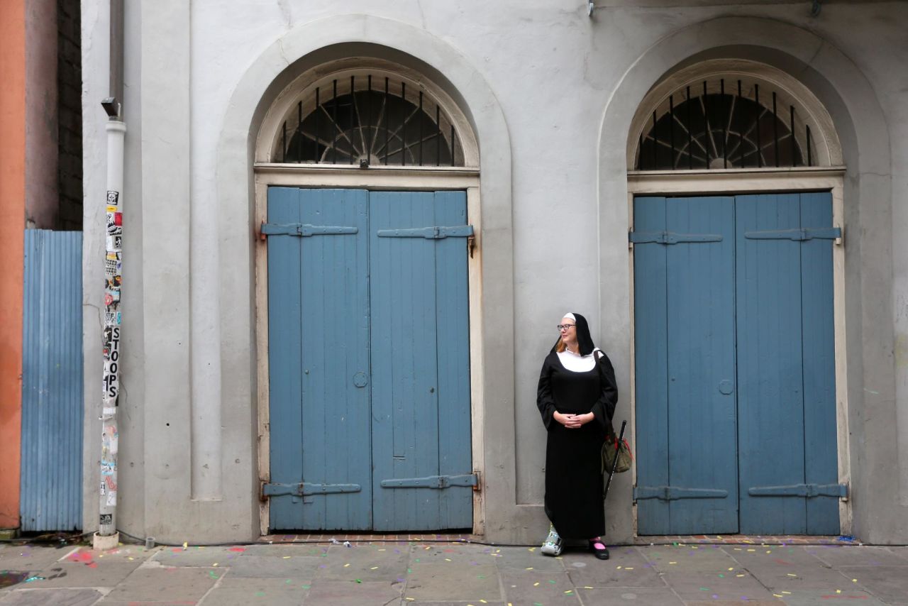 A reveler dressed as a nun rests against a wall during Fat Tuesday celebrations.