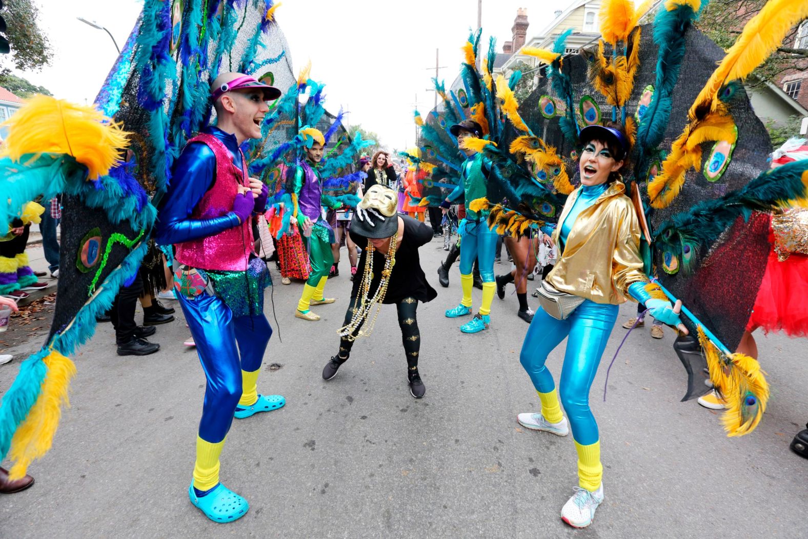 A group of friends calling themselves "The Ostentation" form a dance line with the Society of St. Anne on Royal Street.