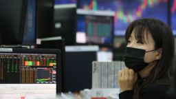 A currency trader wearing a face mask watches monitors at the foreign exchange dealing room of the KEB Hana Bank headquarters in Seoul, South Korea, Friday, Feb. 21, 2020. 