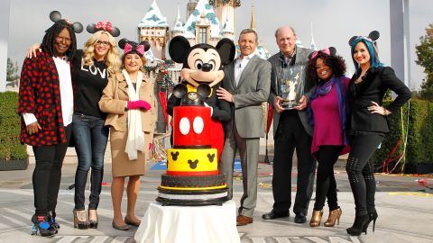 The daytime talk show "The View" is broadcast live from the Disneyland Resort in Anaheim, California, in 2013. From left are Whoopi Goldberg, Jenny McCarthy, Barbara Walters, Mickey Mouse, Iger, Bill Geddie, Sherri Shepherd and Demi Lovato.