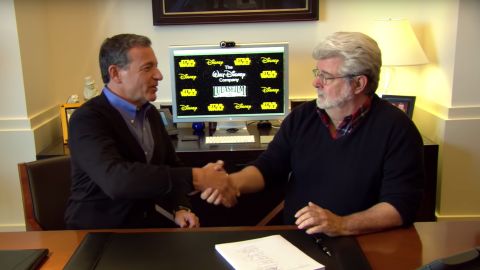 Iger and Lucas shake hands following Disney's acquisition of Lucasfilm in 2012.
