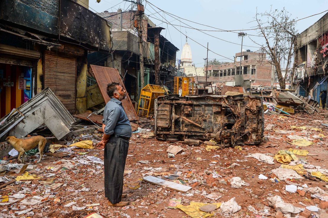 A resident looks at burnt-out and damaged residential premises and shops following clashes on Tuesday.