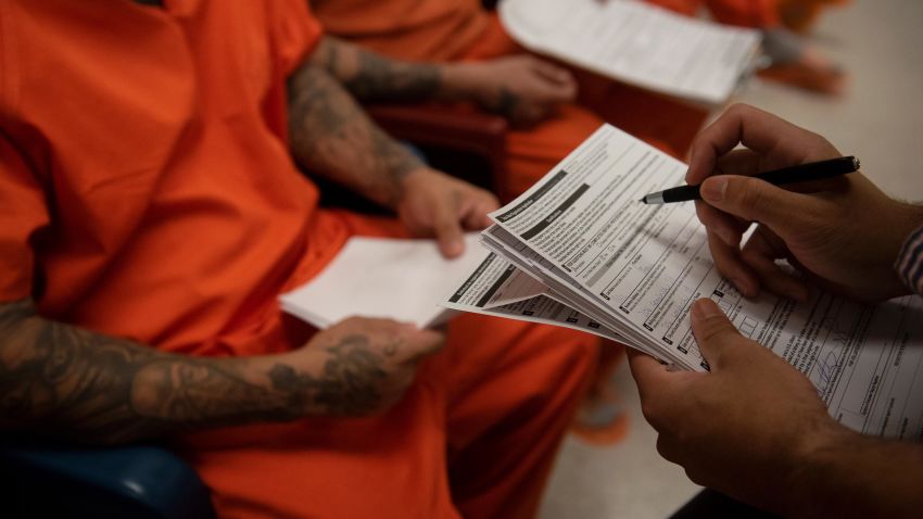 A MOVE Texas employee helps inmates fill out voter registration forms during a civics class at the Bexar County Adult Detention Center in San Antonio, Texas, Thursday, November 7, 2019. In the state of Texas, former felons have the right to vote once they are no longer on probation or parole.