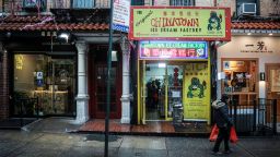 In this Feb. 13, 2020, photo, a woman walks by Chinatown Ice Cream Factory, a neighborhood fixture owned by Christina Seid and built by her father four decades ago in New York. "I'm probably more American than a lot of the people asking me about coronavirus," said Seid. "It's a little annoying to be honest." (AP Photo/Bebeto Matthews)