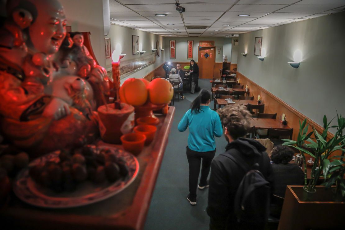 A Buddhist prayer shrine sits on a shelf over-looking a near empty Vegetarian Dim Sum restaurant in New York's ChinaTown, usually bustling with afternoon customers, Thursday Feb. 13, 2020, in New York.