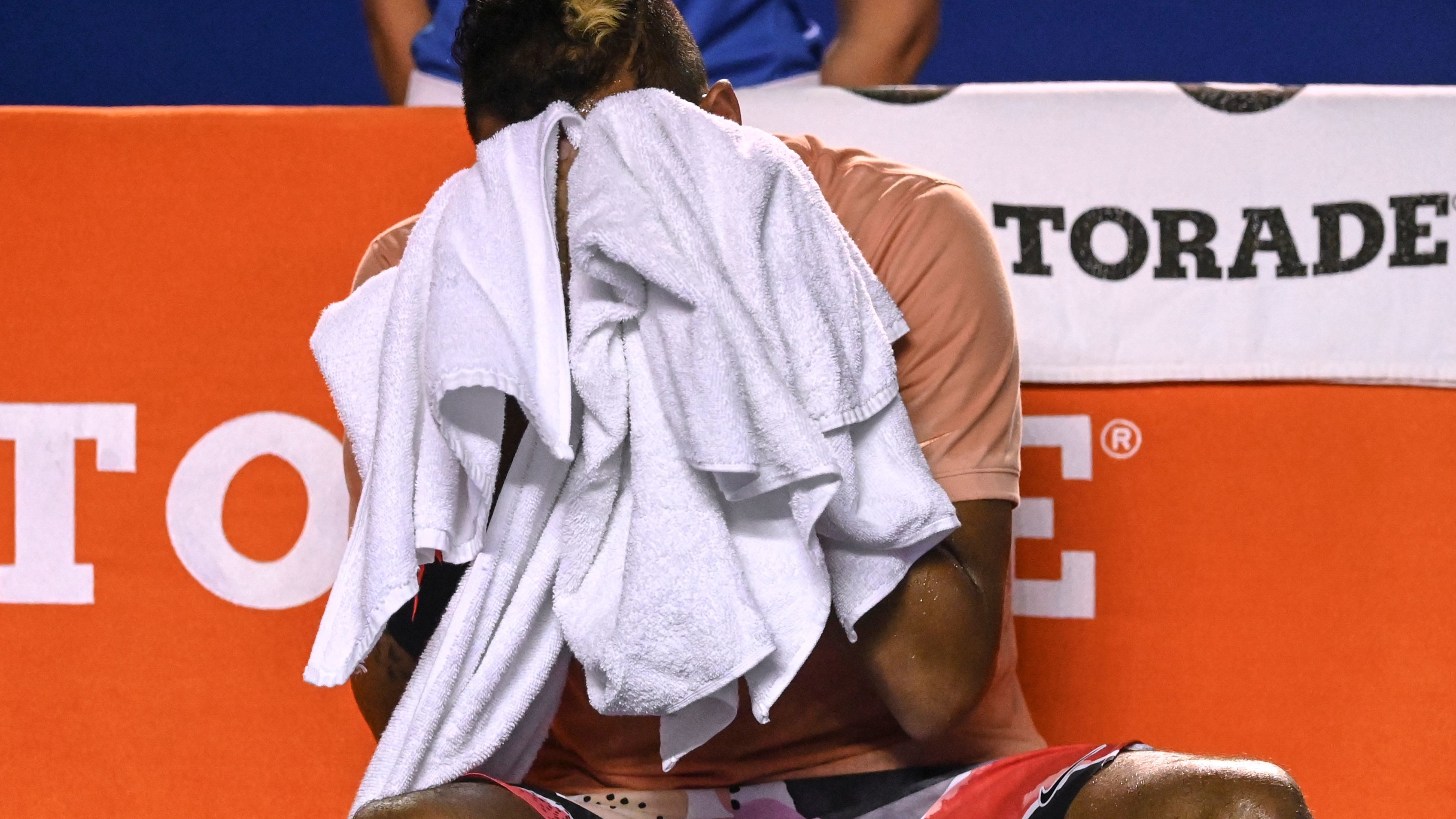 Nick Kyrgios wipes his face before withdrawing from his Mexican Open.