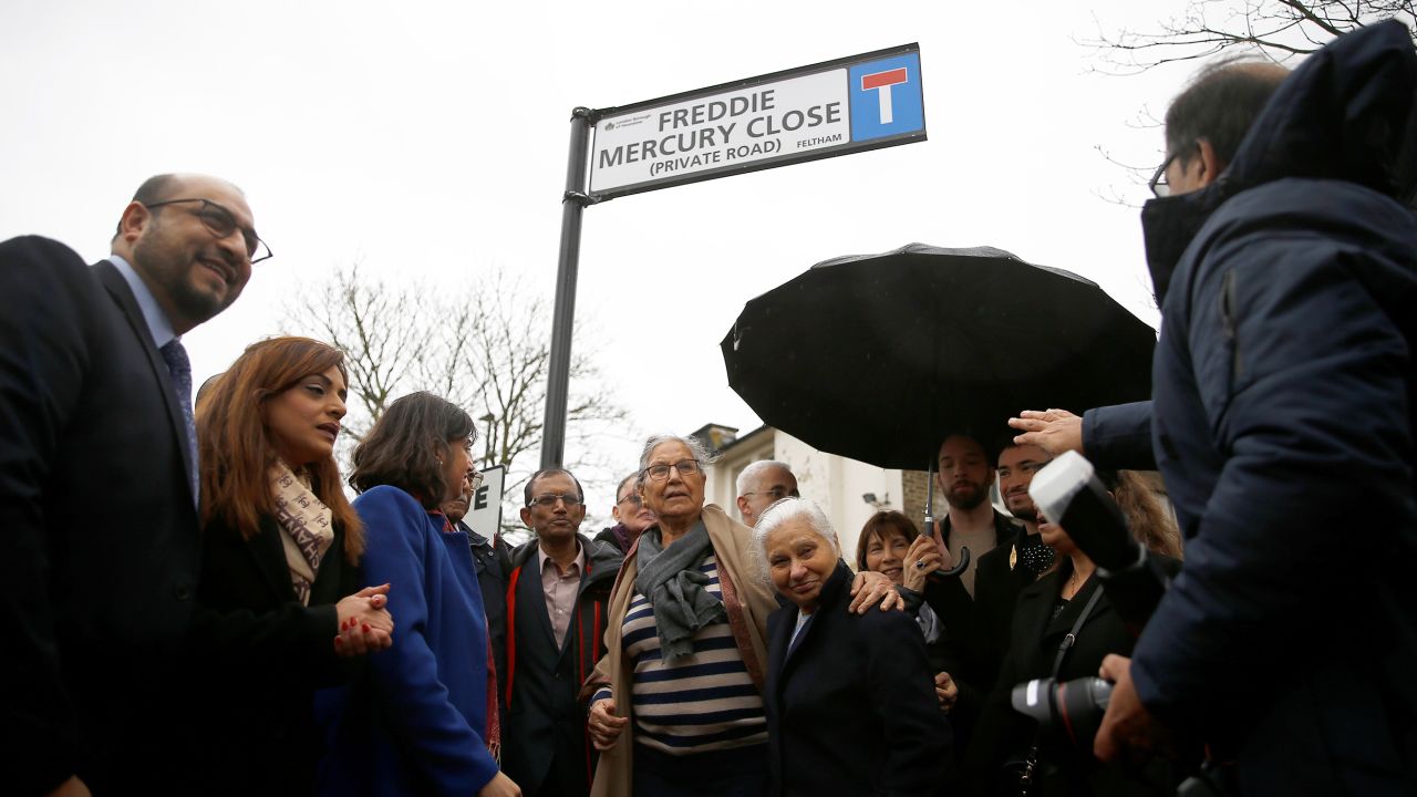Kashmira Bulsara, sister of the late singer Freddie Mercury, and Mayor of Hounslow Tony Louki (back) gather under the unveiled sign during a ceremony to rename a street in Feltham "Freddie Mercury Close," in Greater London. 