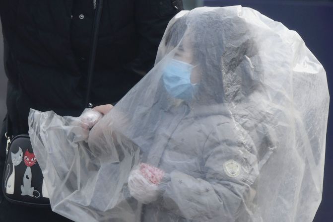 A child is covered with a plastic bag before getting into a taxi in Beijing on February 13.