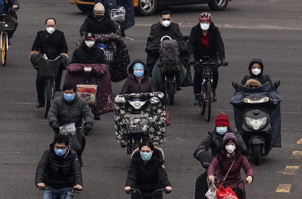 Commuters in Beijing wear protective masks as they ride bikes and scooters across an intersection during rush hour on February 24. Nearly everyone in Beijing and across mainland China is wearing a protective mask outdoors, if they go out at all; some instead choose to stay home as much as possible, in line with the government's recommendation to self-quarantine and avoid public gatherings.