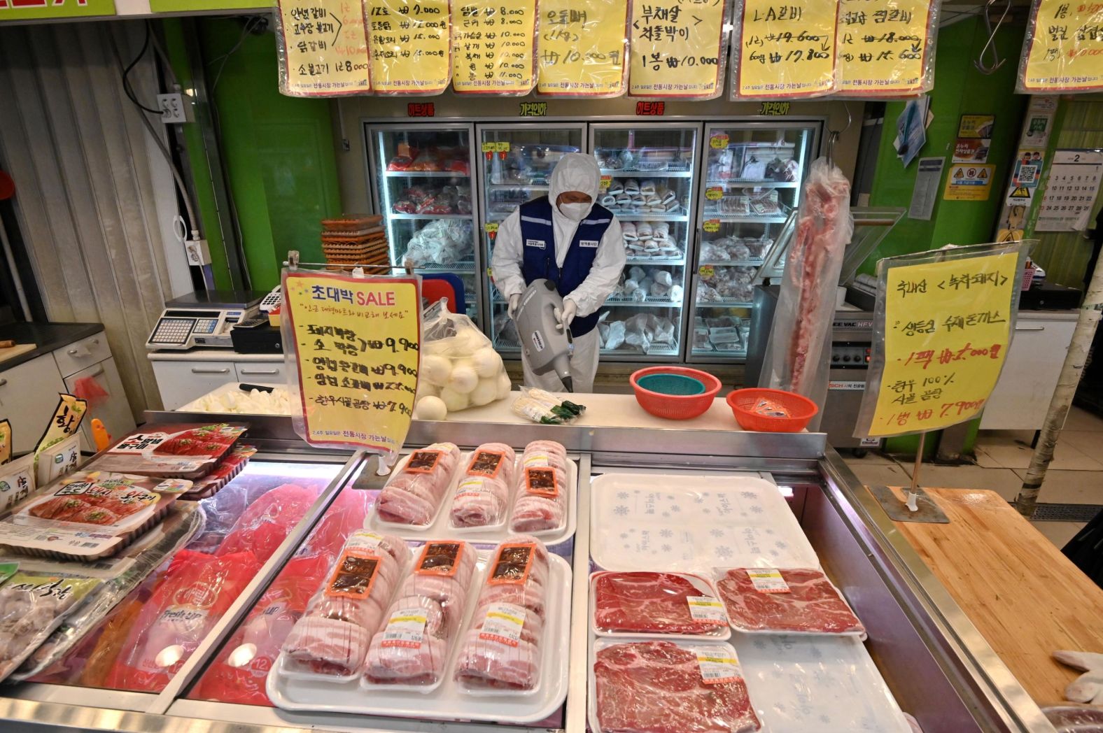 A worker from the Korea Pest Control Association, wearing protective gear, sprays disinfectant at a market in Seoul on February 24. South Korea has seen a spike in numbers as a new outbreak spreads across the country. There are now more than 1,500 cases nationwide, many of which are linked to a religious group in the south of the country.