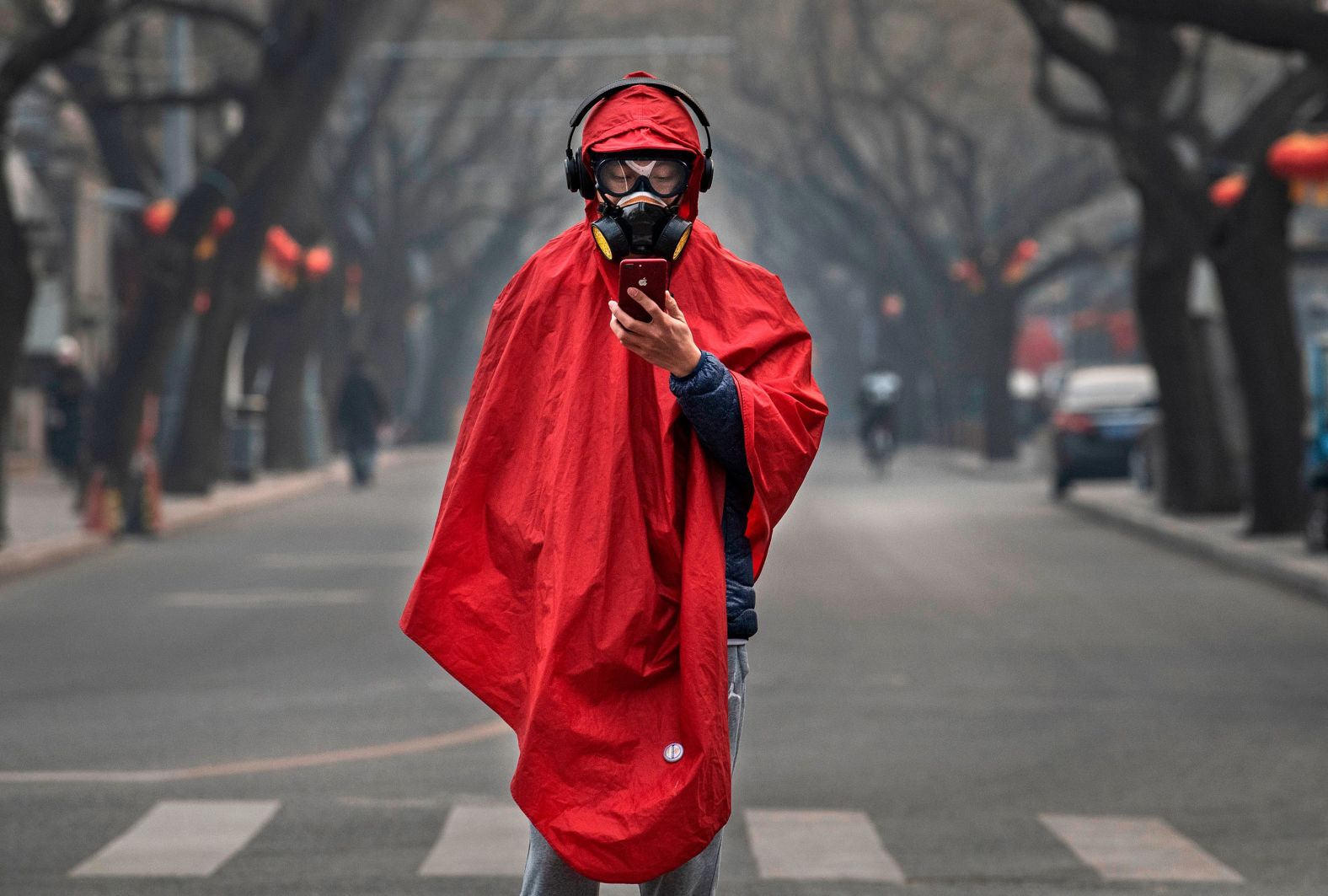 A Chinese man wears a protective mask, goggles and coat on a nearly empty street on January 26 in Beijing, China. The outbreak hit during Chinese New Year -- China's busiest annual travel season. This year, celebrations were canceled, travel restrictions were implemented, and the typical festive atmosphere was replaced by one of fear and caution.