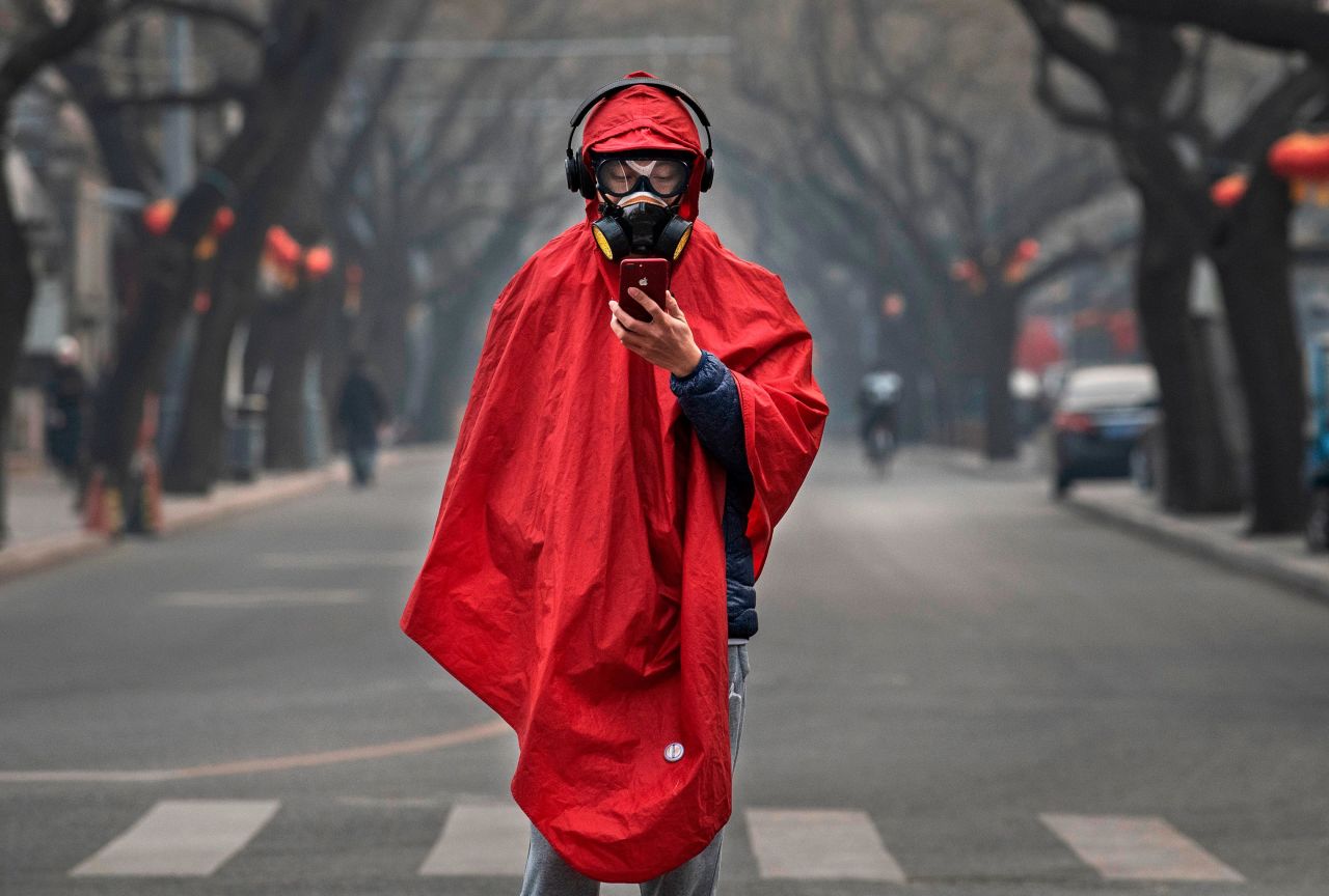 A Chinese man wears a protective mask, goggles and coat on a nearly empty street on January 26 in Beijing, China. The outbreak hit during Chinese New Year -- China's busiest annual travel season. This year, celebrations were canceled, travel restrictions were implemented, and the typical festive atmosphere was replaced by one of fear and caution.