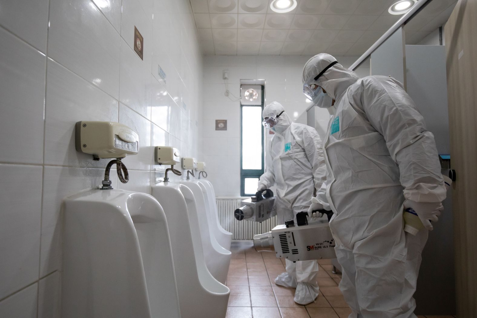 Workers spray disinfectant inside a toilet at a bus depot in Seoul, South Korea, on February 24. The majority of cases in South Korea have taken place in the southern city of Daegu, but infections have also spread to other places like Busan -- the country's second most populous city.