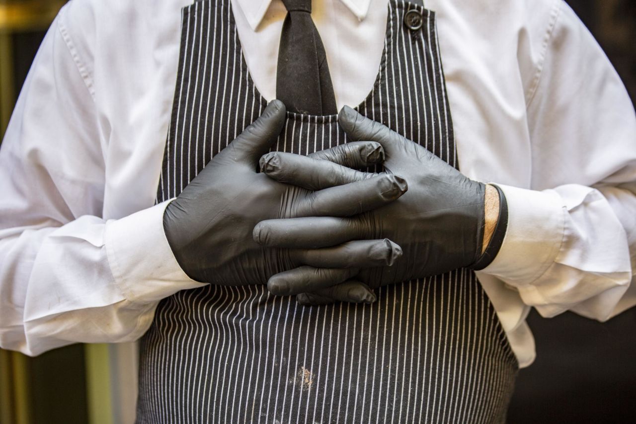 A worker wears disposable latex gloves while serving food at a cafe in Milan, Italy, on February 24. Italy is now the largest outbreak outside Asia, and is at the heart of the European outbreak. Since Italy's outbreak, the virus has spread to many other nearby countries; Norway, Denmark, Austria, Romania, Georgia, and North Macedonia all reported their first cases within a week.