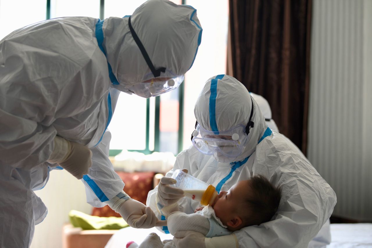 Temporary "mothers" Zhang Xiaoyan and Wang Simei feed the 2-month-old child of a coronavirus patient in China's Anqing City on February 20. The baby's mother was confirmed with coronavirus after all other adult members of her family were also infected -- leaving two children without caretakers. In response, six  local nurses stepped in to act as the children's temporary "mothers."