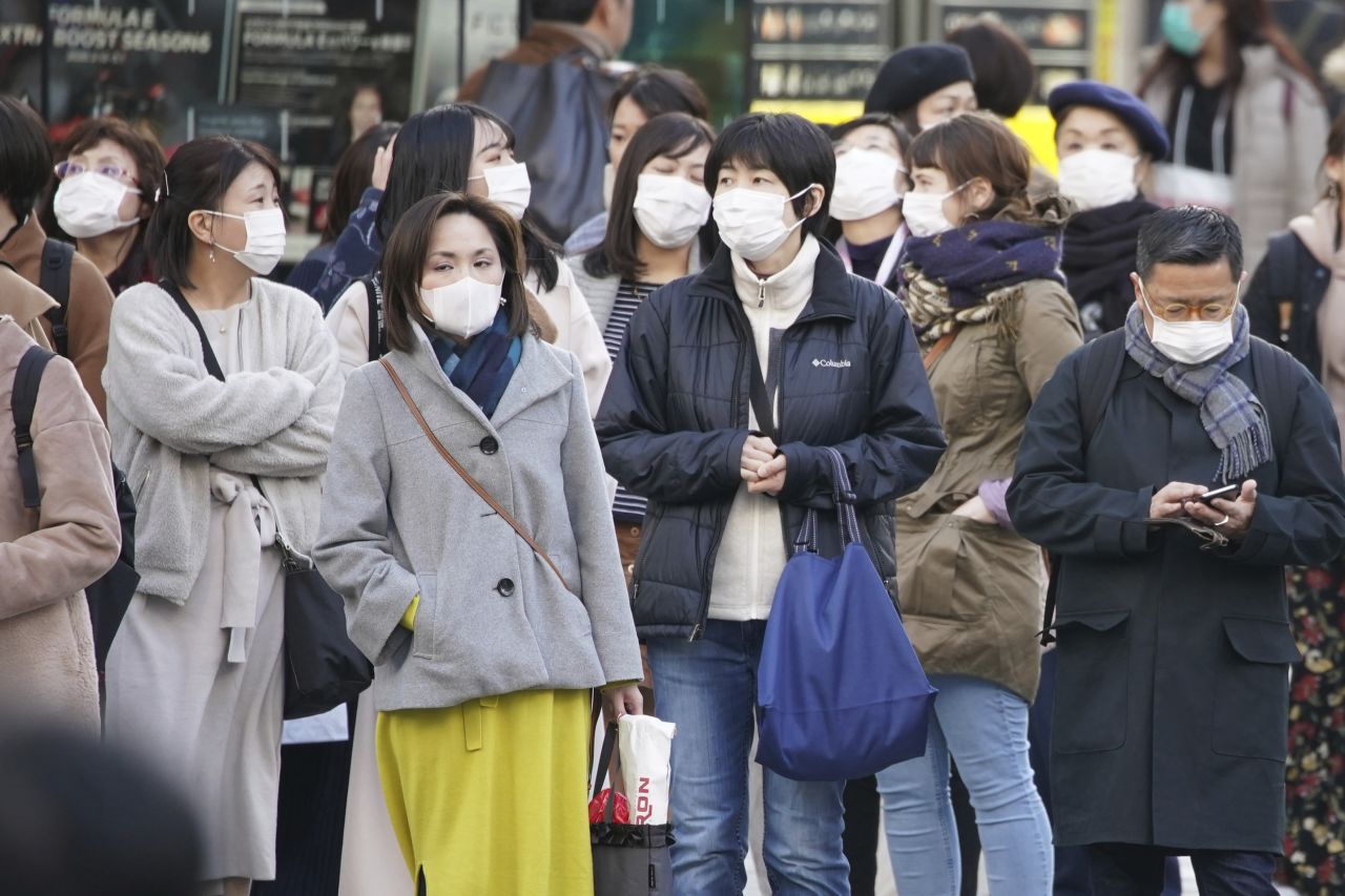 People wear face masks in Tokyo on February 23. Japan came under international scrutiny after the Diamond Princess cruise, docked in Yokohama, was placed under quarantine for weeks with infected passengers on board.