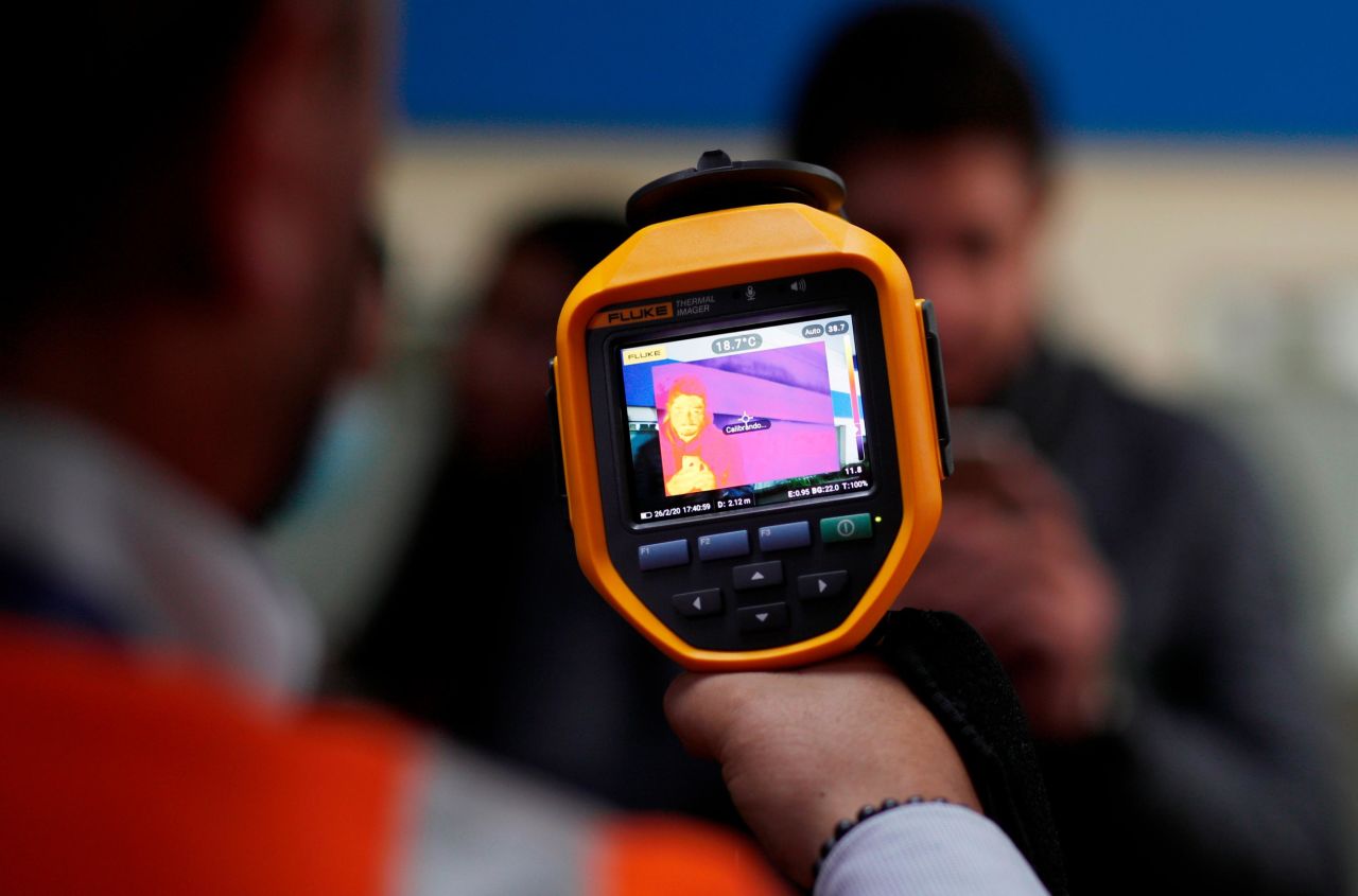 An airport employee scans people's body temperatures in Bolivia on February 26. Brazil reported its first case of the coronavirus that day -- the first case in Latin America. Other nearby countries are now attempting to block the possible spread of the virus.