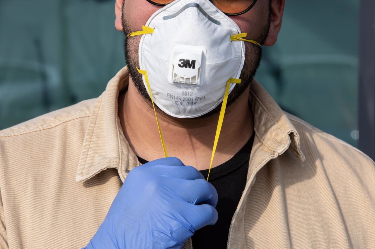 A man wearing a respiratory mask and gloves in Milan, Italy, on February 23. He is in Casalpusterlengo -- one of the ten small towns placed under lockdown as new coronavirus deaths sparked fears throughout the Lombardy region of Italy. The travel restrictions have effectively quarantined 100,000 people in the region.