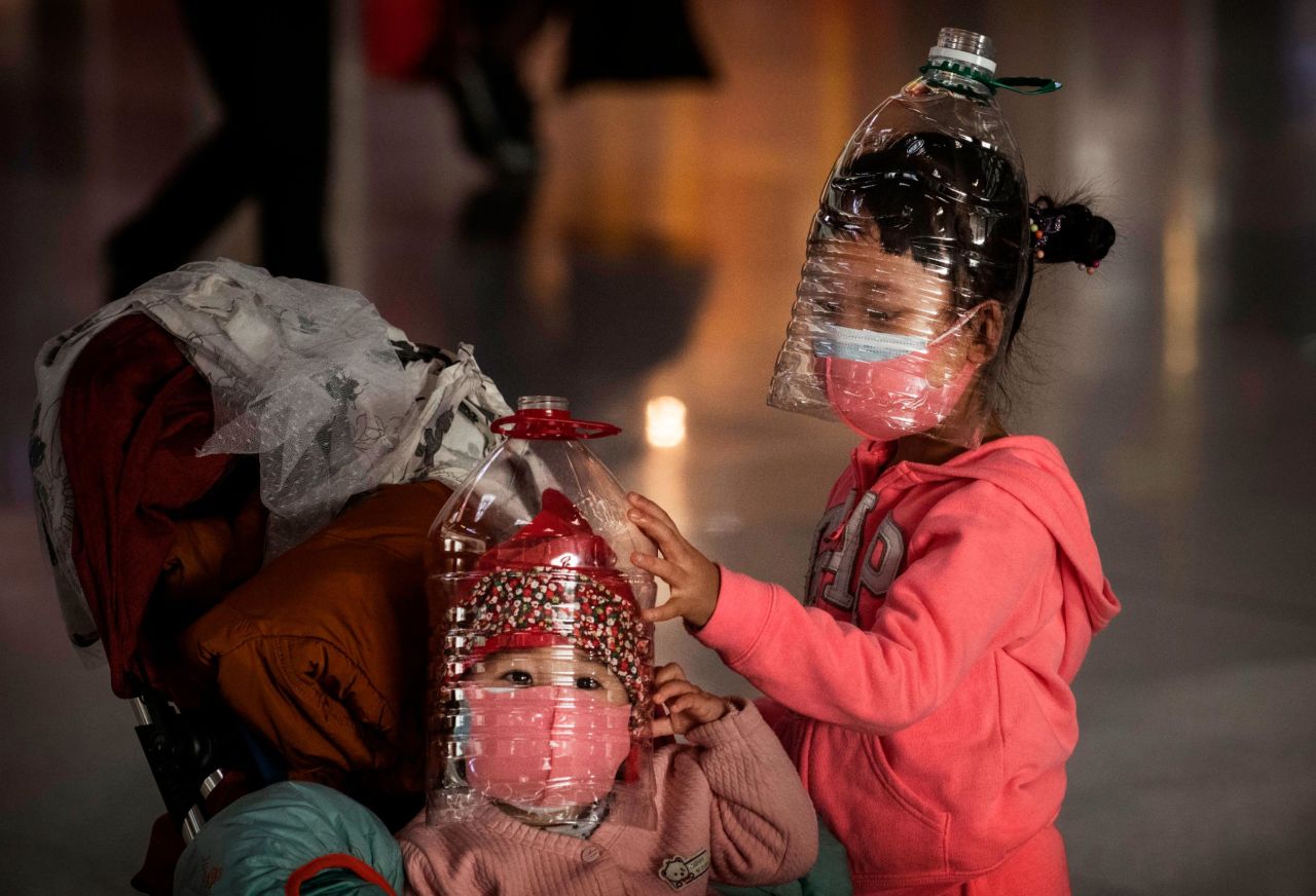 Chinese children wear plastic bottles as makeshift homemade protection at the airport in Beijing on January 30. People in China aren't taking any chances. Apart from just face masks, they have turned to other ways to protect themselves from the virus in public, like wearing full-body plastic ponchos, shower caps, goggles, gloves, and more.