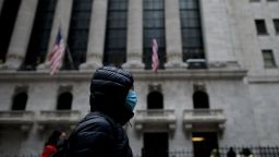 A woman with a facial mask passes the New York Stock Exchange (NYSE) on February 3, 2020 at Wall Street in New York City. - Wall Street stocks rose early Monday, bouncing after Friday's rout as markets monitored the coronavirus at the start of a week with key economic data and earnings reports. The Dow suffered the worst losses of the year on Friday as the death toll from the virus continued to climb and the ailment spread to additional countries. (Photo by Johannes Eisele/AFP/Getty Images)