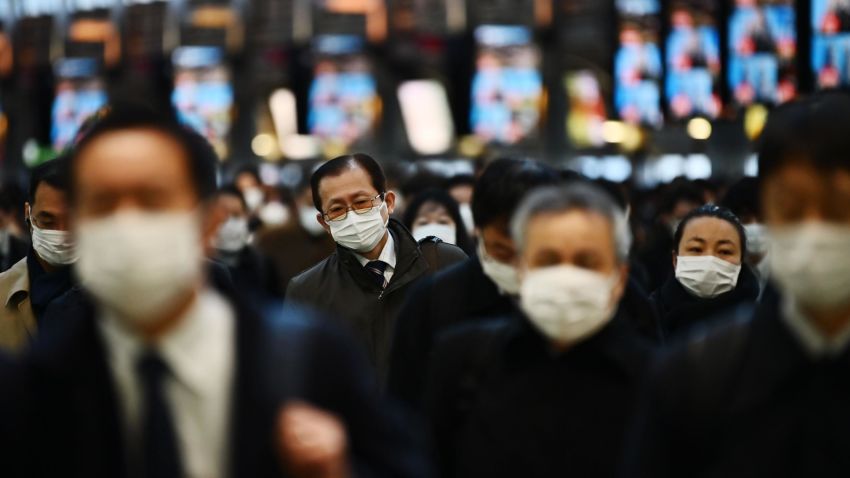 Mask-clad commuters make their way to work during morning rush hour at the Shinagawa train station in Tokyo on February 28, 2020. - Tokyo's key Nikkei index plunged nearly three percent at the open on February 28 after US and European sell-offs with investors worried about the economic impact of the coronavirus outbreak. (Photo by CHARLY TRIBALLEAU / AFP) (Photo by CHARLY TRIBALLEAU/AFP via Getty Images)