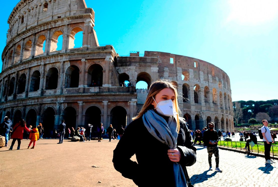Tourist wearing a protective respiratory mask tours outside the Colosseo monument in downtown Rome on February 28.