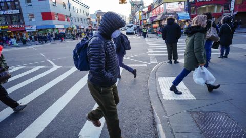 People wear protective masks to fend off the coronavirus, while street vendors peddlel hand sanitizer and other disinfecting products in Queens, New York.