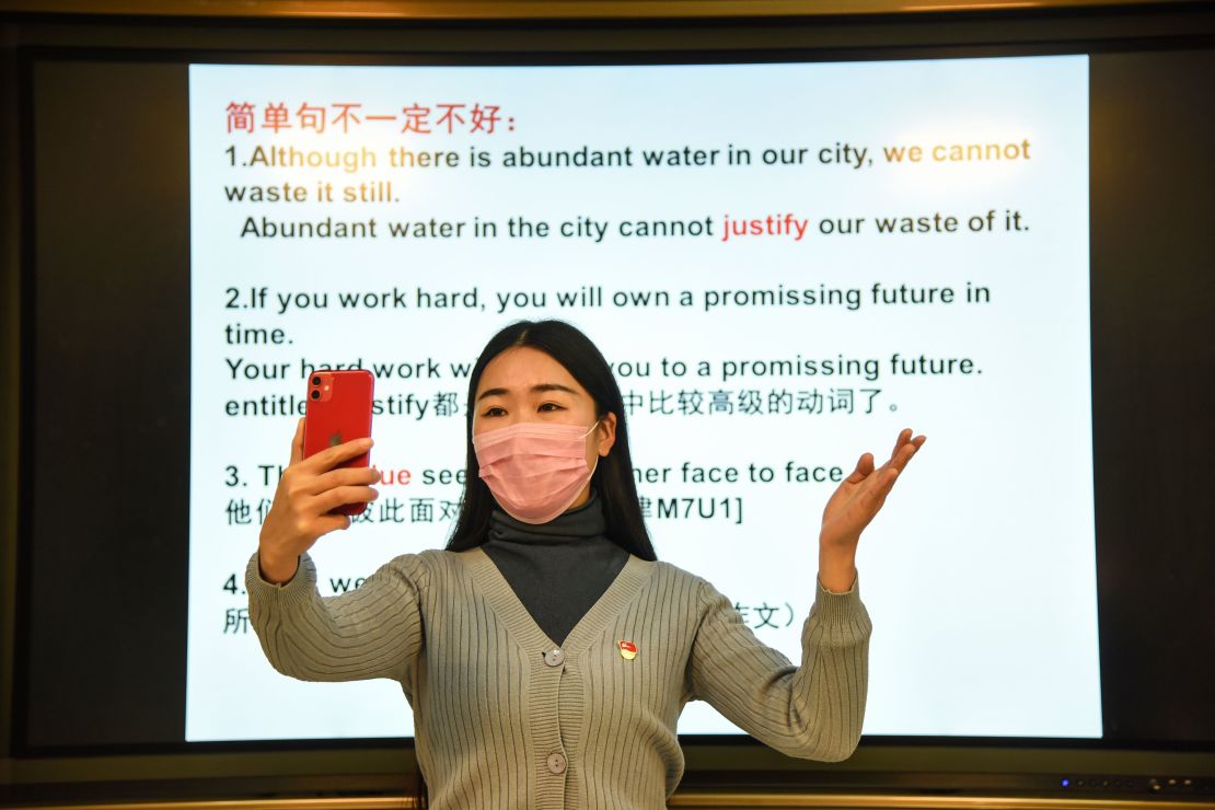A teacher gives a lecture with her smart phone during an online class at a middle school in Donghai in China's eastern Jiangsu province on February 17, 2020. 