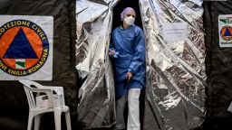 A paramedic wearing a mask exits a tent set up outside the emergency ward of the Piacenza hospital in northern Italy.