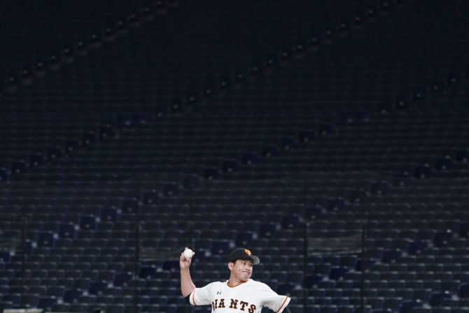 Tomoyuki Sugano, a professional baseball player on the Yomiuri Giants, throws a pitch in an empty Tokyo Dome during a preseason game on February 29, 2020. Fans were barred from preseason games to prevent the spread of the coronavirus.