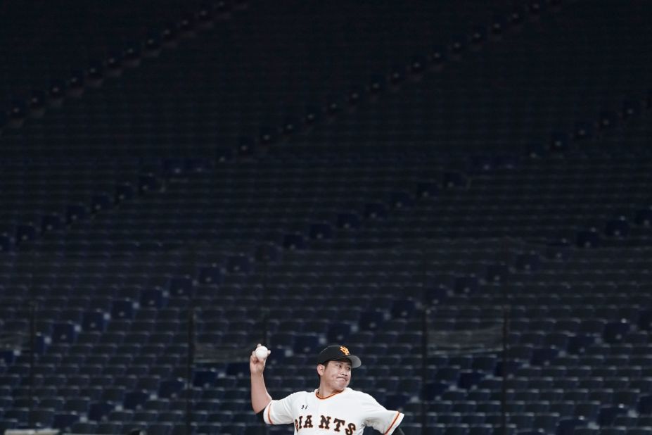 Tomoyuki Sugano, a professional baseball player on the Yomiuri Giants, throws a pitch in an empty Tokyo Dome during a preseason game on February 29. Fans have been barred from preseason games to prevent the spread of the coronavirus.