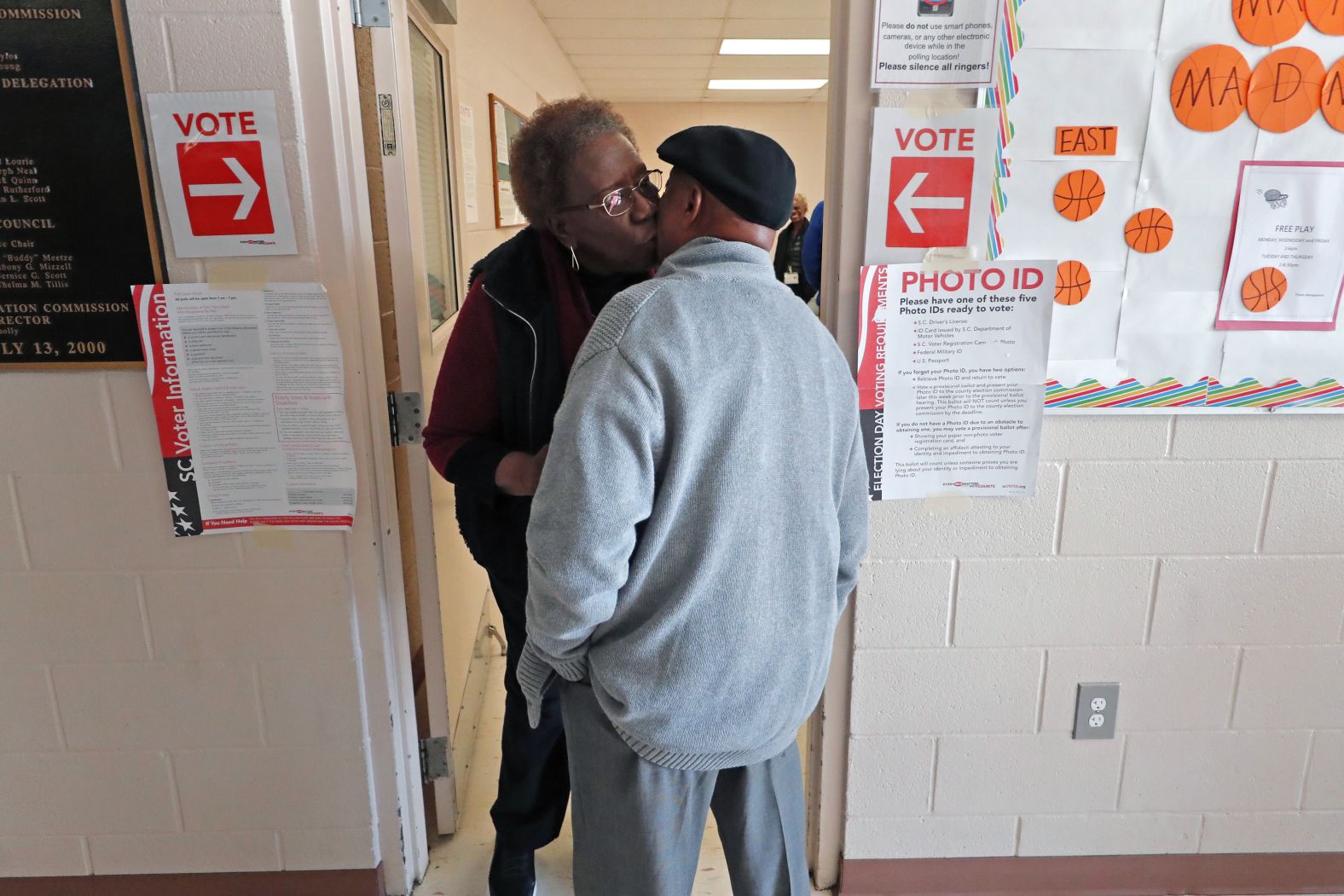 Bernice Scott kisses the cheek of friend Harry Thompson as he arrives to vote in Hopkins.