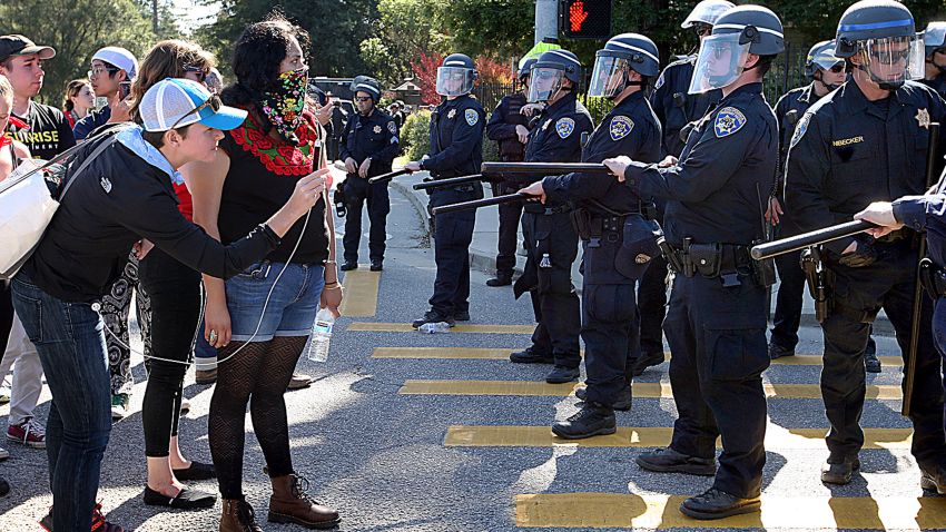 In this photo taken Wednesday, Feb. 12, 2020, University of California police contain demonstrators in the intersection of Bay and High streets, in Santa Cruz, Calif. Officials say at least 17 people were arrested during the third day of a wildcat strike by University of California, Santa Cruz graduate students demanding higher pay. The Santa Cruz Sentinel reports that police arrested the group Wednesday after demonstrators blocking an intersection near campus ignored multiple orders to disperse. (Dan Coyro/Santa Cruz Sentinel via AP)