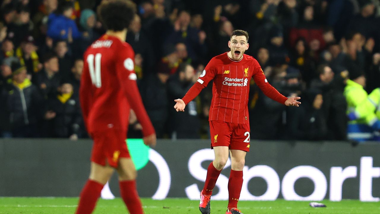 Andy Robertson shouts towards teammate Mohamed Salah.