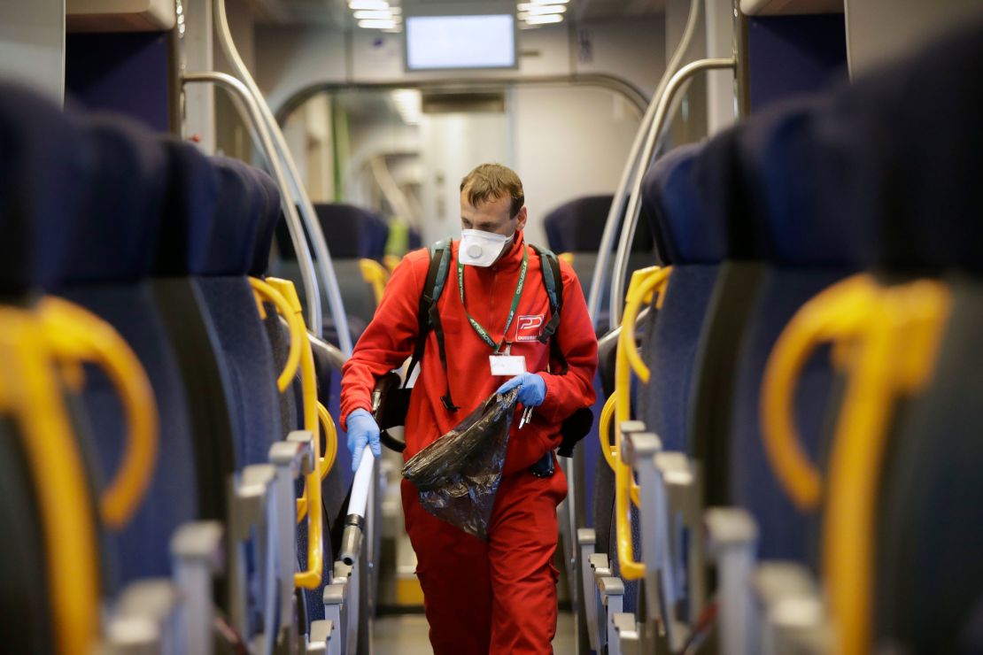 A worker sanitizes a car on a regional train in Milan on Friday.