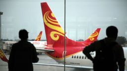 Passengers look at planes belonging to China's Hainan Airlines at the gate at Haikou airport in south China's Hainan province on June 12, 2014.